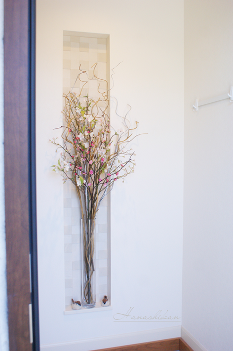 一般住宅玄関のニッチに飾った桜と桃の花ディスプレイフラワー