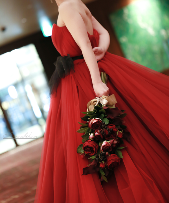 下向きに持ったボルドーカラーのアームブーケ